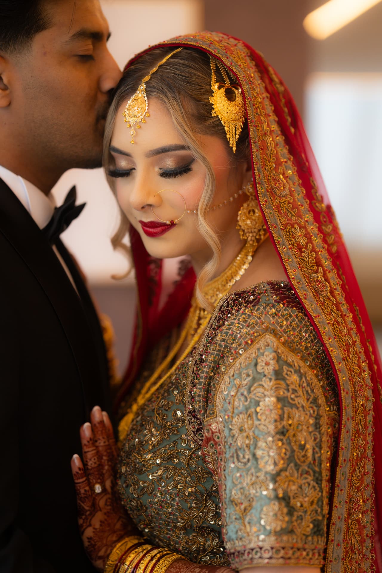 Groom kissing his bride's forehead in an intimate bridal portrait