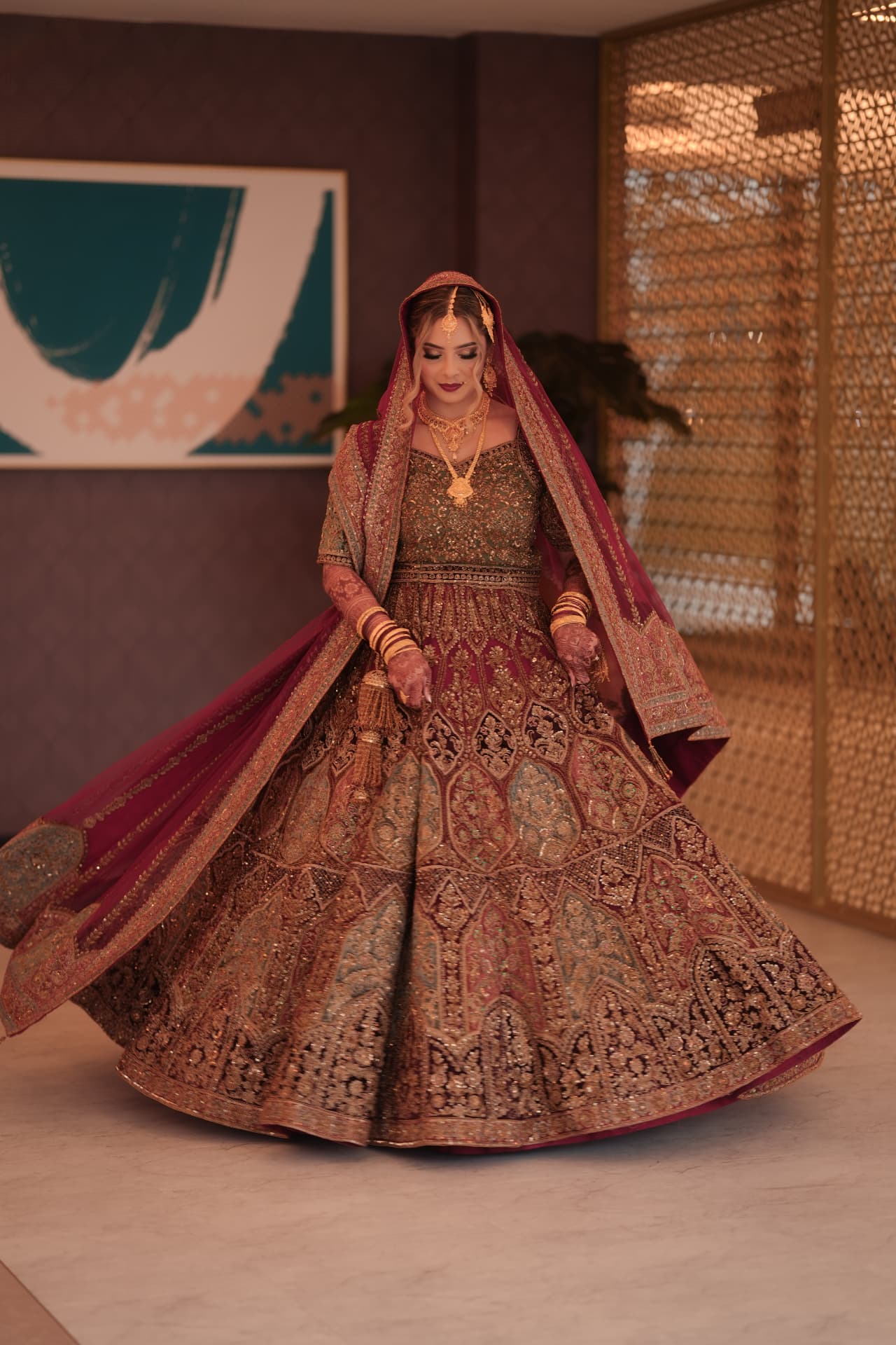 Bride showcasing her intricately embroidered red and gold lehenga