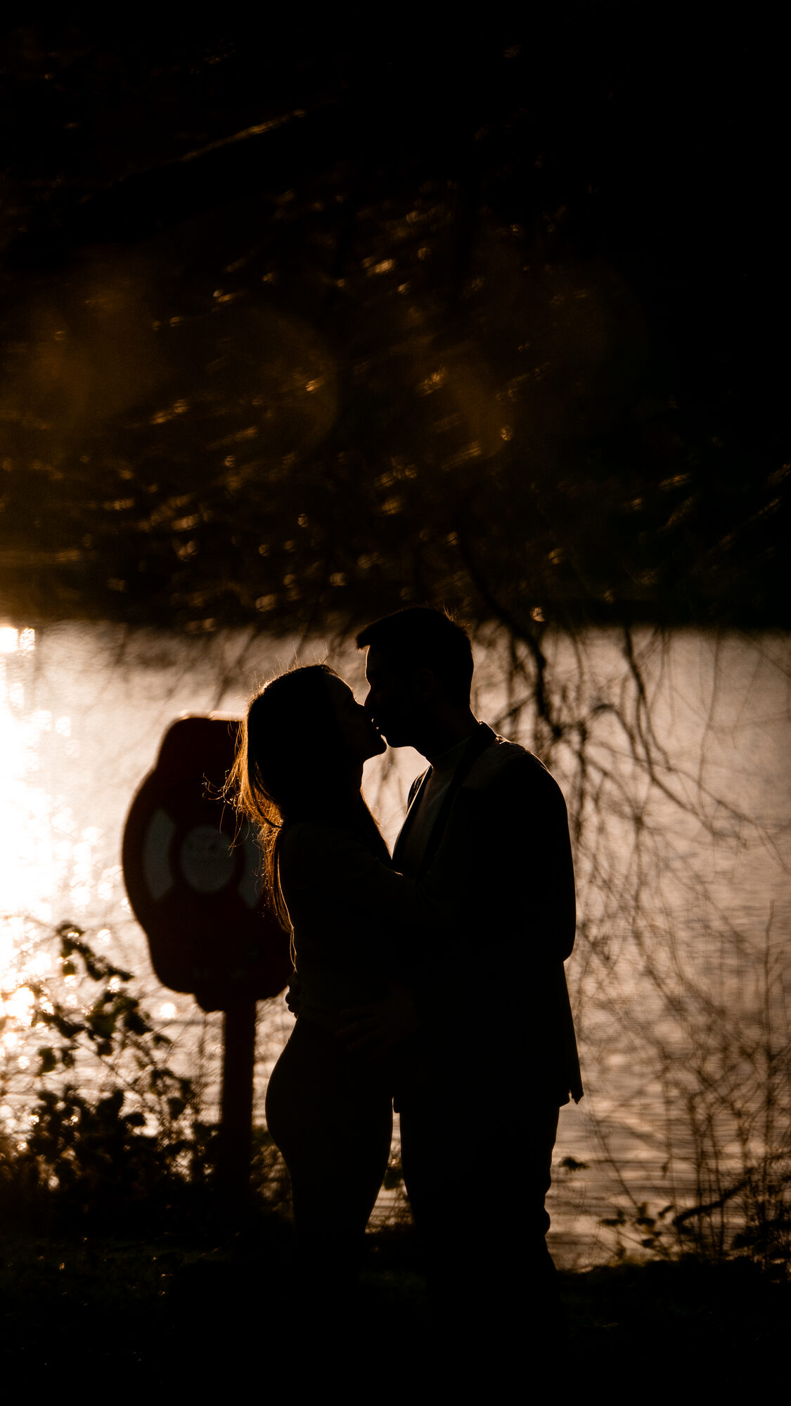 Engaged couple framed inside a stone archway at the University of Birmingham