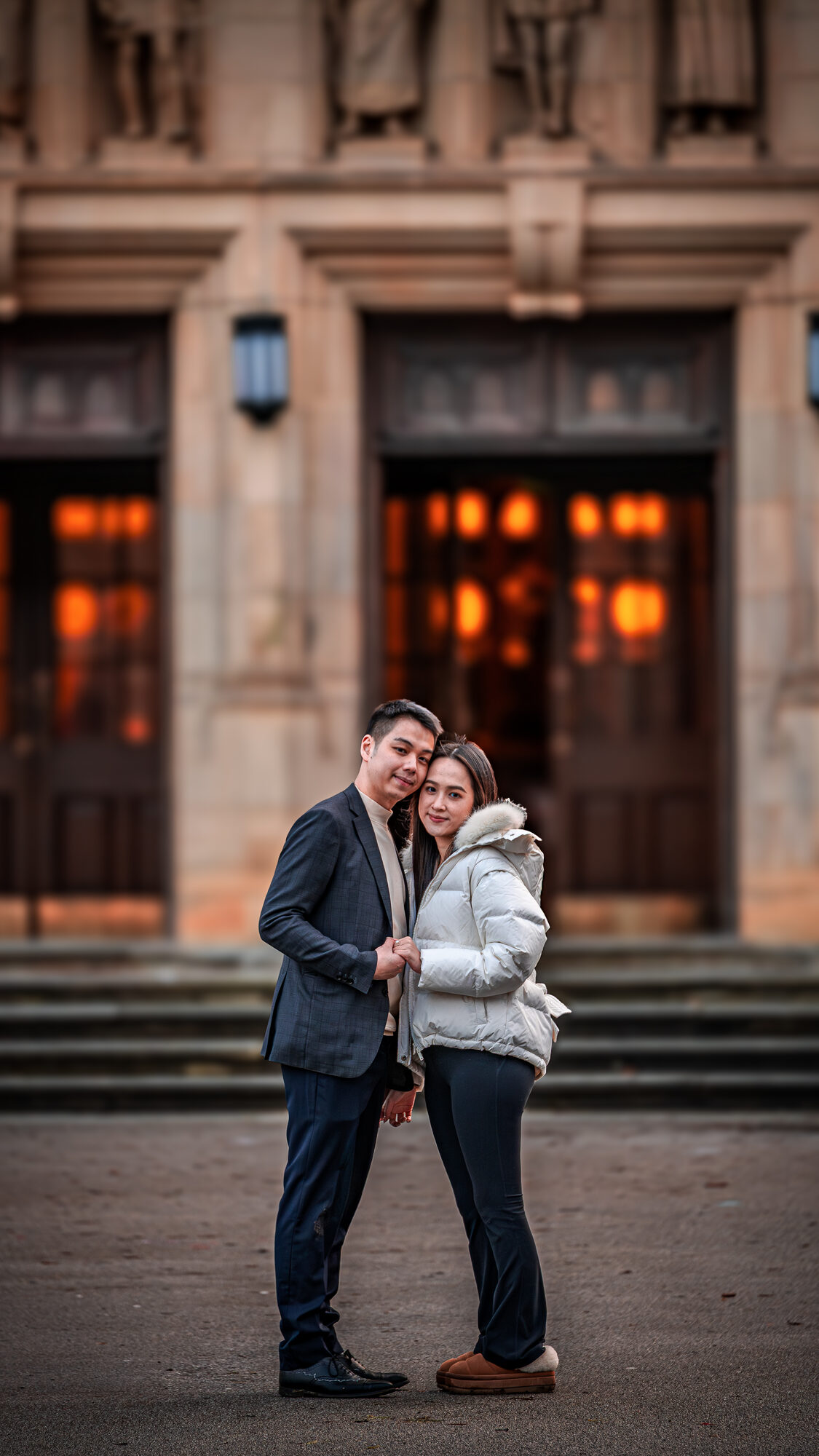Couple posing in front of warm-lit doorways at golden hour, Birmingham