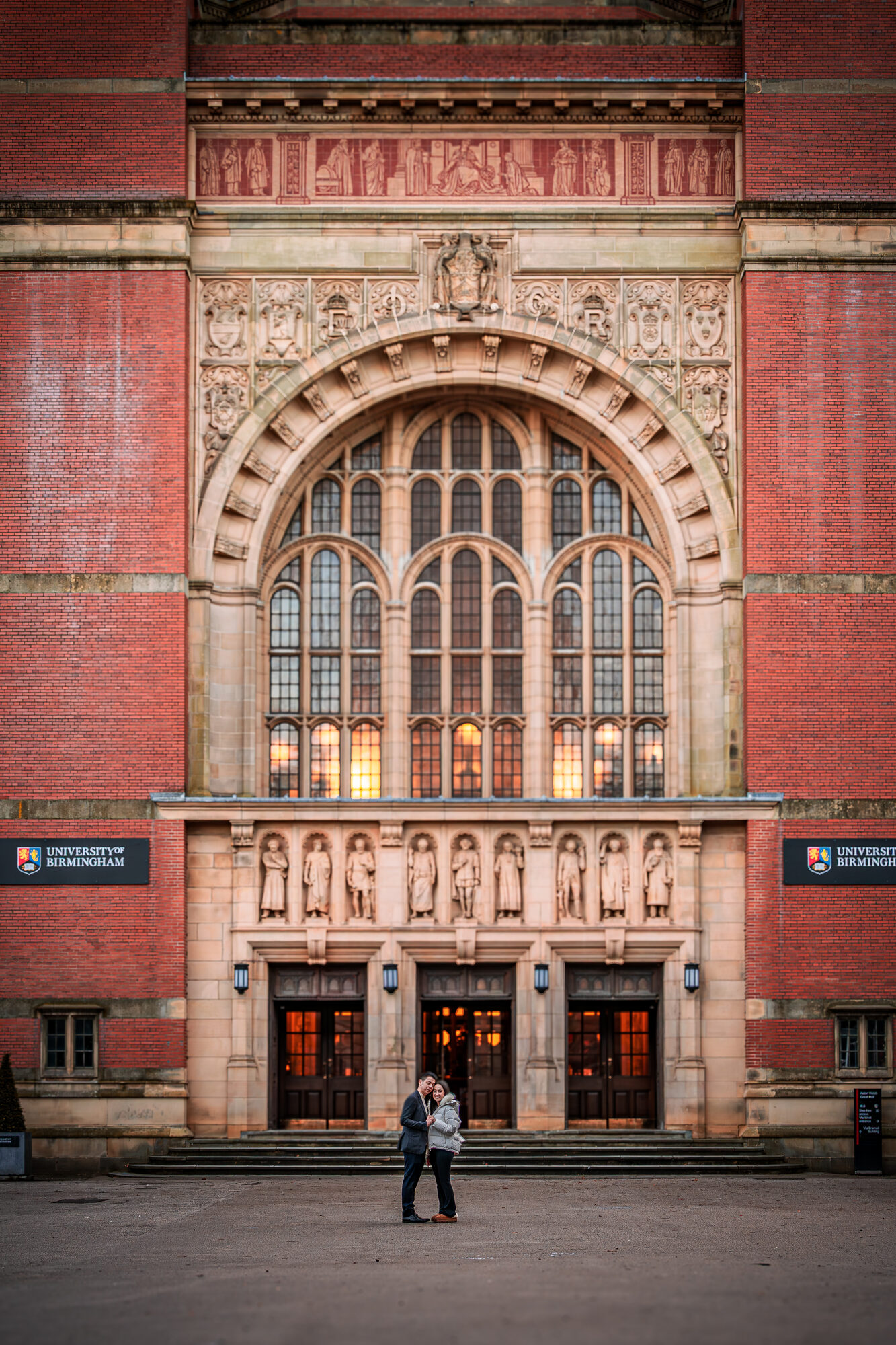 Engaged couple kissing surrounded by white florals at golden hour, Birmingham