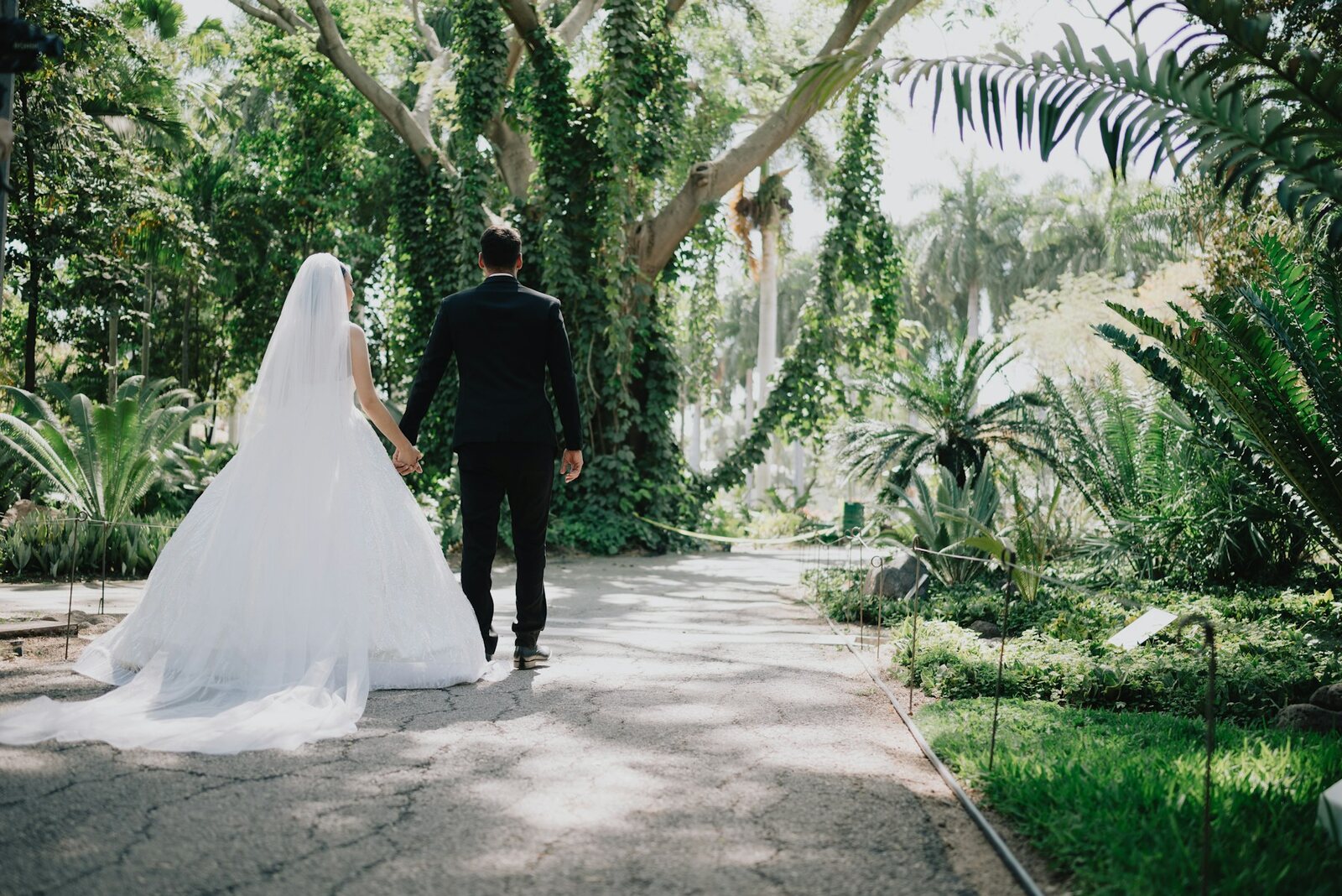 English bride and groom walking through a UK garden