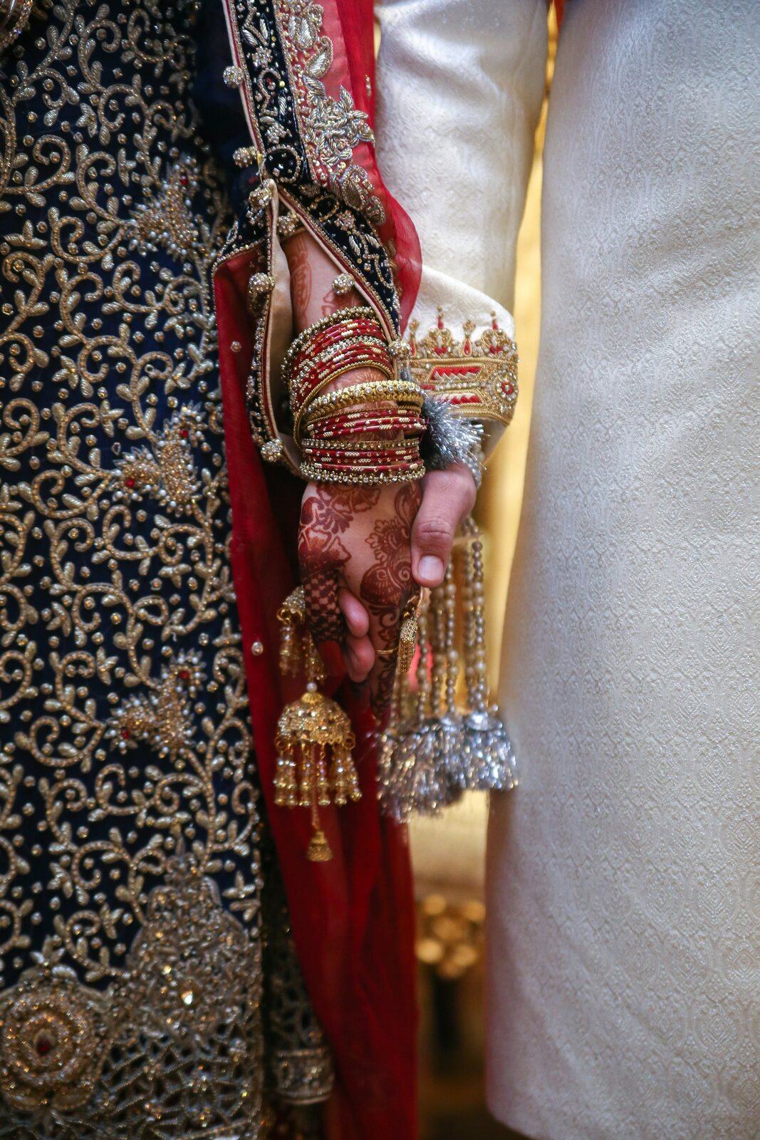 bride detail in red and gold lehenga with bangles